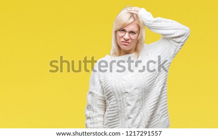 Young beautiful blonde woman wearing winter sweater and glasses over isolated background confuse and wonder about question. Uncertain with doubt, thinking with hand on head. Pensive concept.