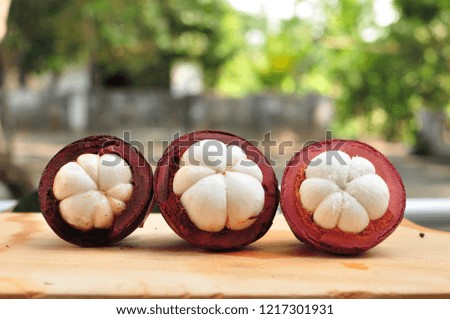 Mangosteen fruit, cross section showing the thick purple skin, queen of fruits. Royalty-Free Stock Photo #1217301931