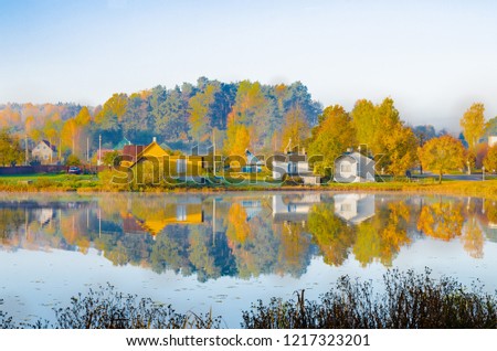 the lake is surrounded by autumn trees reflected in the mirror surface of the lake, quiet morning