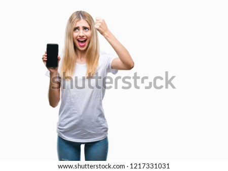 Young beautiful blonde woman showing smartphone over isolated background annoyed and frustrated shouting with anger, crazy and yelling with raised hand, anger concept