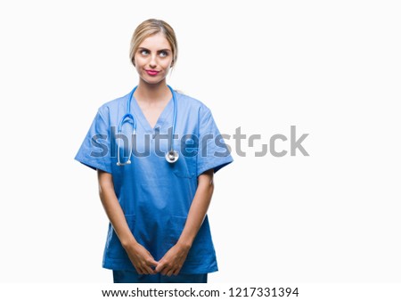 Young beautiful blonde doctor surgeon nurse woman over isolated background smiling looking side and staring away thinking.