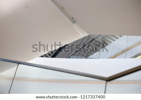 Generic architectural elements. Close-up photo of modern office architecture building interior. Typical structure of multilevel room with transparent balustrade of staircase and pitched ceiling.