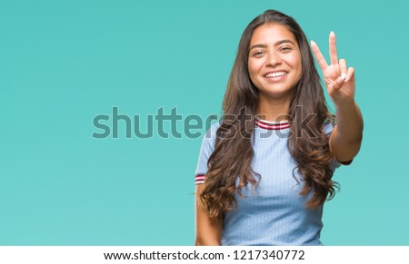 Young beautiful arab woman over isolated background smiling with happy face winking at the camera doing victory sign. Number two.