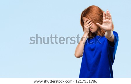 Young beautiful woman over isolated background covering eyes with hands and doing stop gesture with sad and fear expression. Embarrassed and negative concept.