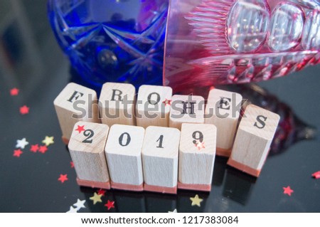 Happy New Year 2019 in wooden letters, golden and red stars on a black background