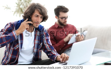 guy with a friend sitting at the desk.