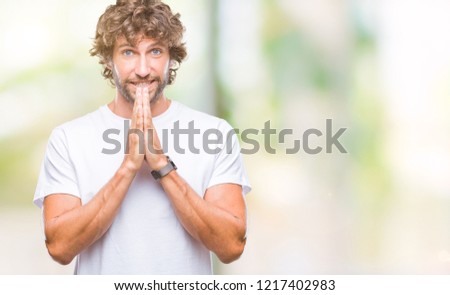 Handsome hispanic model man over isolated background praying with hands together asking for forgiveness smiling confident.