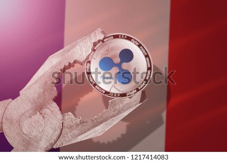 RIPPLE (XRP) coin being squeezed in vice on France flag background; concept of ripple cryptocurrency  under pressure. Prohibition of cryptocurrencies, regulations, restrictions or security