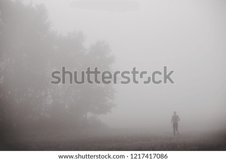 Runner silhouette in blue autumn morning mist