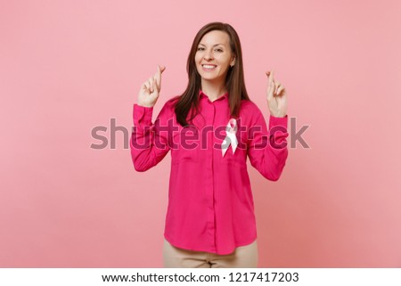 Woman in rose clothes with pink silk ribbon symbol isolated on pastel wall background, studio portrait. Medical healthcare gynecological oncology, Breast Cancer Awareness concept. Mock up copy space