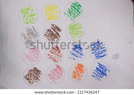 Child drawing a pastel crayon in circle