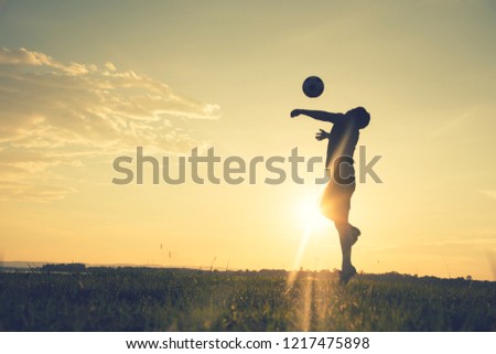 Soccer player man standing Rear View in silhouette isolated on sunset background