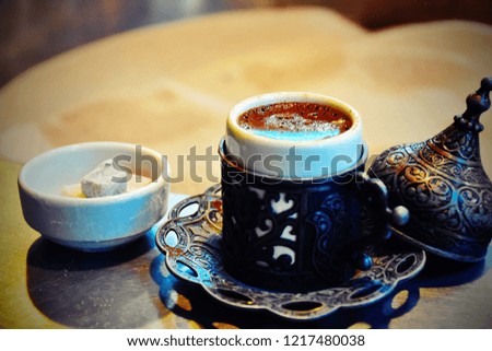 Turkish coffee in copper with delight beside hot sand in pot for boiling coffee, vintage traditional hot beverage in natural process concept, vintage tone with filter with shadow