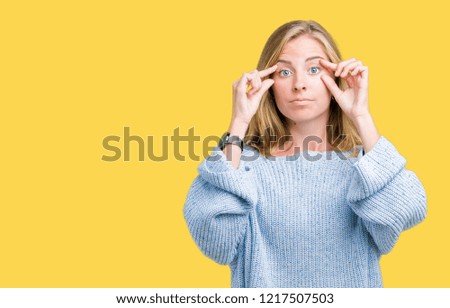 Beautiful young woman wearing blue sweater over isolated background Trying to open eyes with fingers, sleepy and tired for morning fatigue