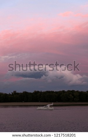 Passenger boat floating on the Dnieper River along the Trukhanov Island on the sunset. Kyiv, Ukraine.