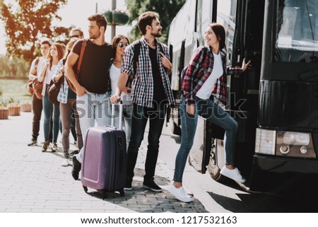 Group of Young People Boarding on Travel Bus. Happy Travelers Standing in Queue Holding Luggage Waiting their turn to Enter Bus. Traveling, Tourism and People Concept. Summer Vacation Royalty-Free Stock Photo #1217532163