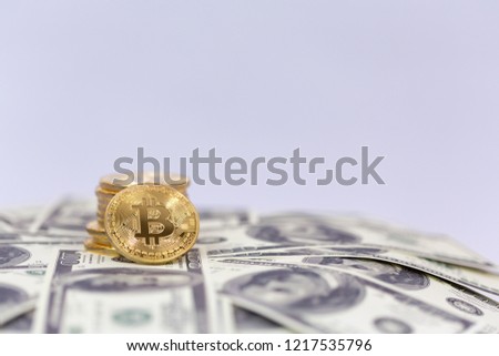 Bitcoin crypto-currency stacked with 100 dollar bills, close up isolated, room for text of background image. 