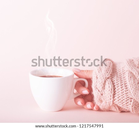 Woman with a cup of fragrant coffee in her hands on a cool day. Black warm coffee in cold weather.