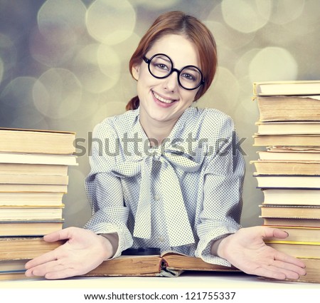 The young teacher in glasses with books. Photo with bokeh at background.