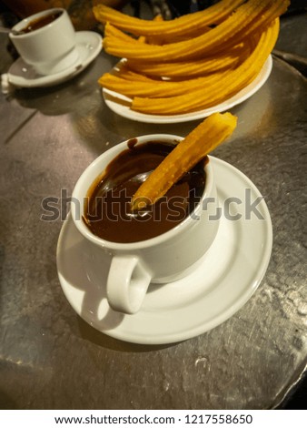 Portrait Picture of Two Chocolate Cups with Curros on the Table