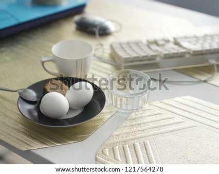 Boiled eggs for breakfast next to computer keyboard, indoors close-up