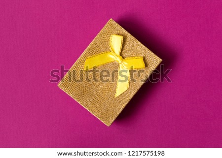 A small gift on a purple background. The concept of a gift made with your own hands.