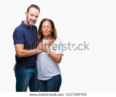 Middle age hispanic casual couple over isolated background smiling with hands on chest with closed eyes and grateful gesture on face. Health concept.
