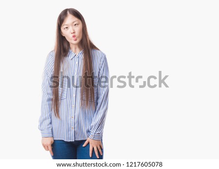 Young Chinese woman over isolated background making fish face with lips, crazy and comical gesture. Funny expression.