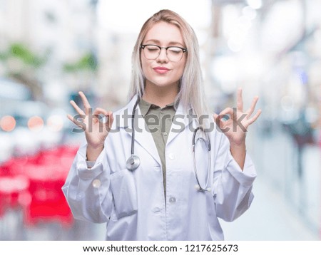 Young blonde doctor woman over isolated background relax and smiling with eyes closed doing meditation gesture with fingers. Yoga concept.