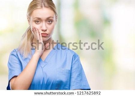 Young blonde surgeon doctor woman wearing medical uniform over isolated background thinking looking tired and bored with depression problems with crossed arms.