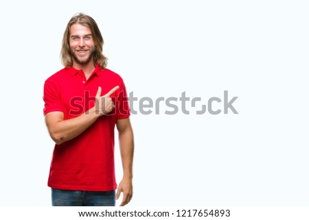 Young handsome man with long hair over isolated background cheerful with a smile of face pointing with hand and finger up to the side with happy and natural expression on face looking at the camera.