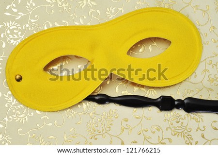 elegant carnival mask with handle on a flower patterned background