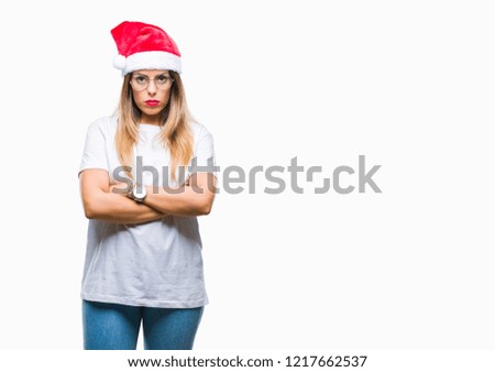 Young beautiful woman wearing christmas hat over isolated background skeptic and nervous, disapproving expression on face with crossed arms. Negative person.