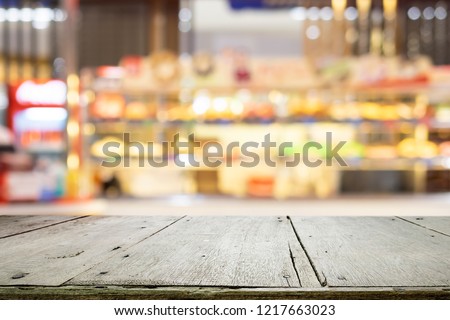 Empty wooden table for present product on coffee shop or soft drink bar blur background with bokeh image.
