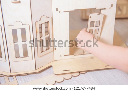 the child collects the house from the wooden designer. a concept on construction of the house.