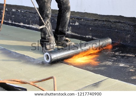 Waterproofing flat roof with bitumen sealing membranes Royalty-Free Stock Photo #1217740900