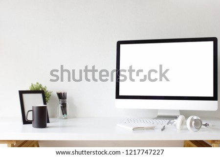 Office table desk. Workspace with blank computer screen, keyboard,  booklet, pen, headphones, empty picture frame, plant mockup, glass bottle, cup, pencils and white background front view