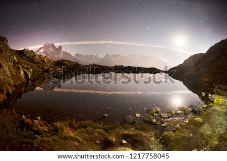 Mont Blanc Chamonix France autumn - night and the starry sky. Clear cold lake Lac Blanc beautiful night against the background of the steep peaks of the Alps with glaciers