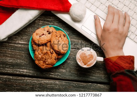 Cookie and woman hand with notebook on wooden table