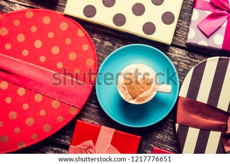 Cup of coffee and christmas gifts on wooden background