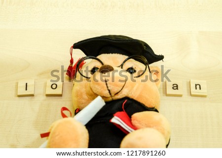 Graduation teddy bear and the word tiles loan.