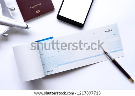 Travel concept. Checkbook, pen, mobile smart phone with empty white screen, passport, airplane model mock up isolated on white background. Business payment by cheque concept.  Royalty-Free Stock Photo #1217897713