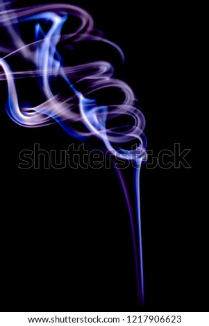 Abstract monochrome smoke trails from an incense on black background.
