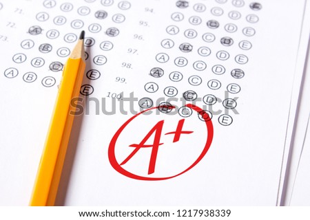 Good grade of A plus (A+) is written with  red pen on the tests. Royalty-Free Stock Photo #1217938339