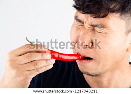 Close-up Portrait of a man eating chili, healthy diet and food concept.People with spicy chili,Red chili Royalty-Free Stock Photo #1217943211