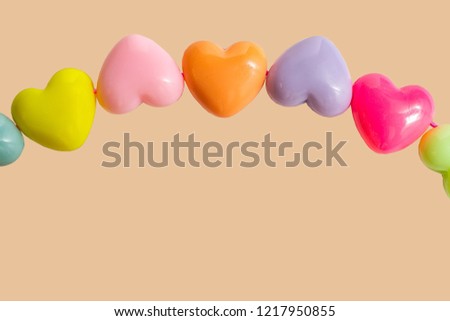 Photo frame from plastic hearts of different colors on colored backgrounds