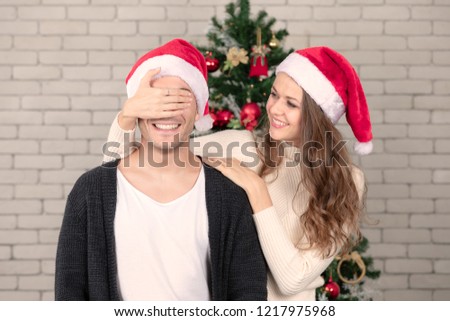 Young and beautiful caucasian woman standing behind beautiful woman and close his  eyes with smiling and happiness face of both together. Concept for good moment and sharing best time in christmas