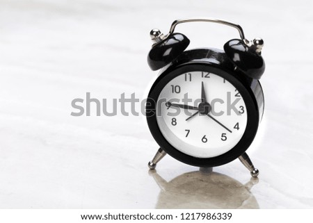 black vintage alarm clock on color background