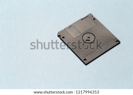 Black floppy disk on light gray background close up