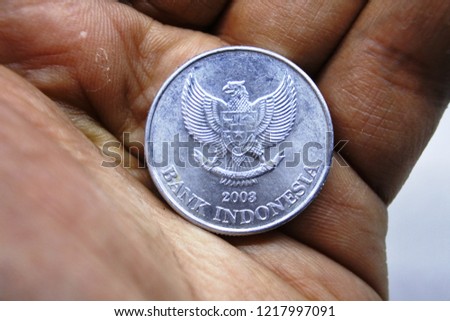 close up of an Indonesian 1000 rupiah coin on hand